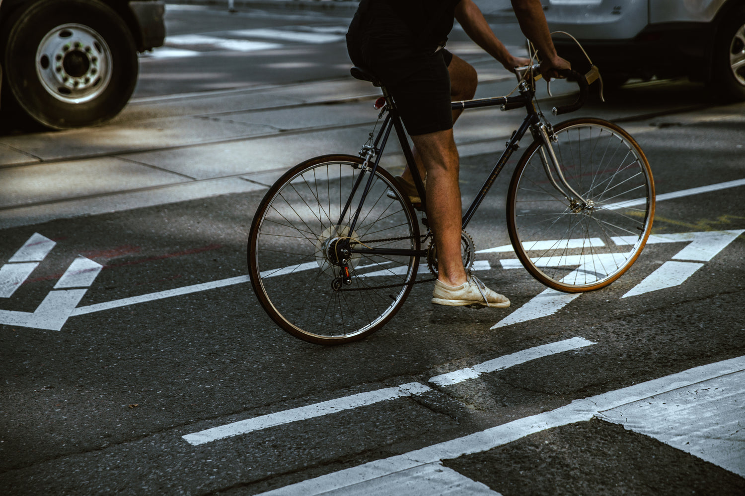 Rennradfahrer mit Rennrad auf städtischem Radweg