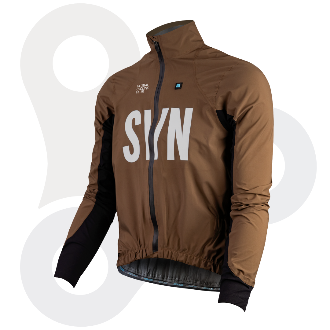 SYN Defender Stay Dry Regenjacke in der Farbe "pale rust" (ein rostiges braun) mit weißem SYN Schriftzug , seitlich von vorne fotografiert