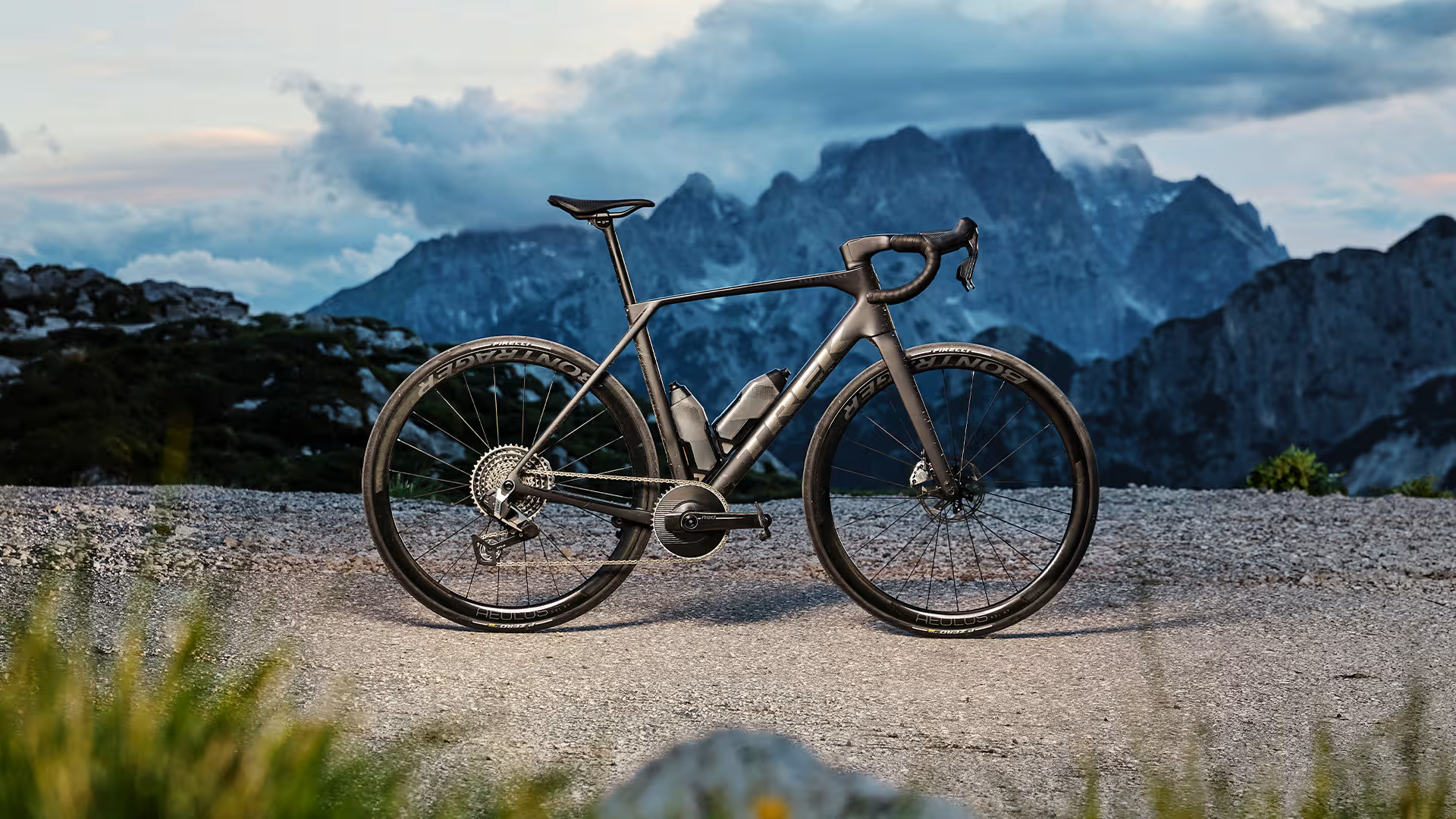 Trek Domane Gen 5 Promobil mit einbem grauen Trek Domane Rennrad vor bergiger Kulisse