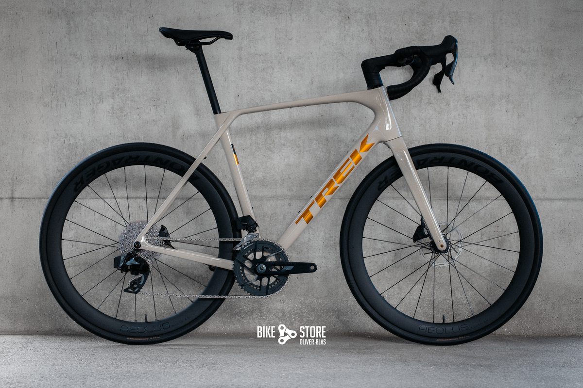 Trek Domane SL5 Gen 5 Rennrad in der Farbe Buff Beige (ein cremiger Weißton) mit goldenem Logo