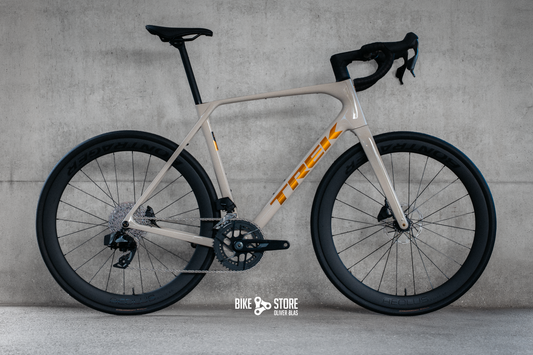 Trek Domane SL6 Gen 5 Rennrad in der Farbe Buff Beige (ein cremiger Weißton) mit goldenem Logo